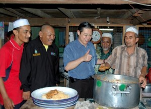 LIM Guan Eng (tiga dari kanan) sambil diperhatikan Abdul Latif Abdullah (dua dari kiri) menunjukkan tanda bagus kepada masakan yang disediakan untuk majlis berbuka puasa di sini baru-baru ini.  