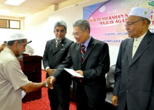 MANSOR Othman (tengah) menyerahkan sumbangan zakat pendidikan bersama-sama SS Hassan Haji Ahmad (kanan) dan Abdul Malik Abul Kassim pada Majlis Penyerahan Bantuan Pendidikan IPT Luar Negara anjuran MAIPP di sini baru-baru ini. 