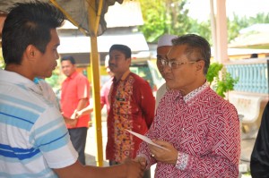 MANSOR Othman bersalaman dengan salah seorang penerima bantuan pada Majlis Penyampaian Sumbangan Mangsa Ribut Pinang Tunggal di Masjid Jamek Al-Hidayah, Kampung Lahar Tiang di sini baru-baru ini.