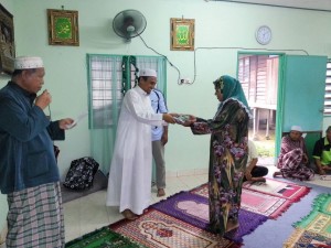 ROSIDI Hussain (dua dari kiri) menyampaikan pakaian mentara wanita pada majlis penyampaian khas di Bakau Tua, di sini baru-baru ini.