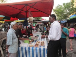 R.S.N Rayer (depan, berkemeja putih) bertanyakan sesuatu kepada peniaga pasar malam Taman Tun Sardon bersempena lawatan khas beliau di sini baru-baru ini.