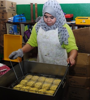 SEORANG kakitangan sedang menggoreng mee sanggul secara manual. 